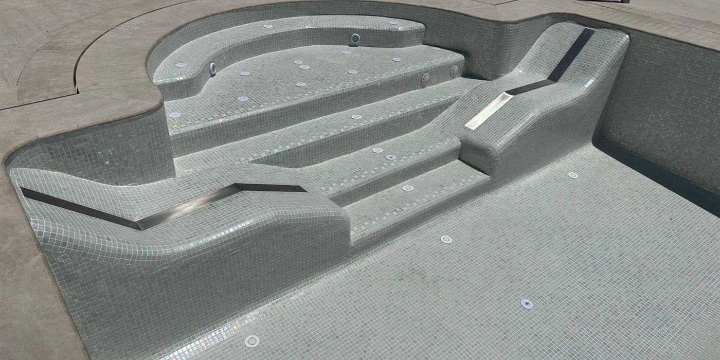 Escalera de una piscina revestida en mosaico, terminada por Ángel Pools Master